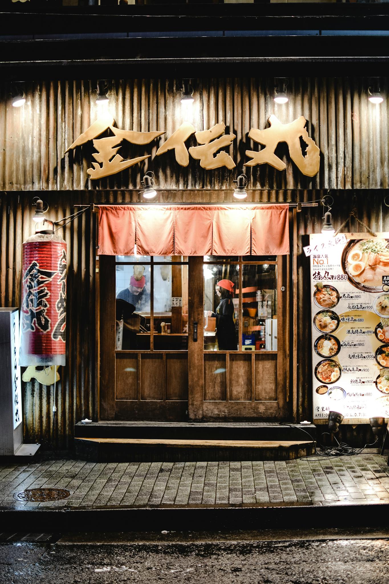 Night view of a traditional Japanese izakaya with glowing signage and inviting entrance.